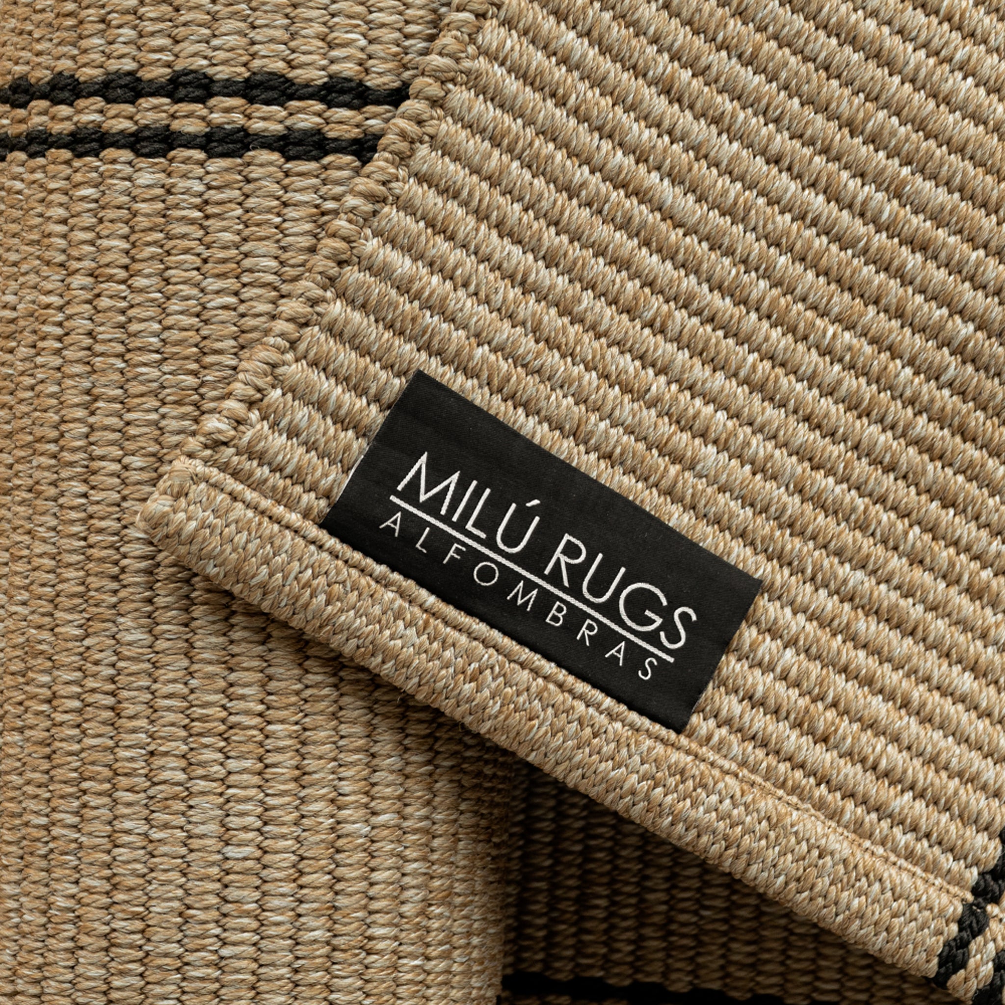Detalle del tejido y etiqueta de la alfombra de pasillo Navi Taupe Black de polipropileno