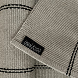 Detalle del tejido y etiqueta de la alfombra Navi Silver Black de polipropileno
