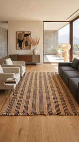 Alfombra Amaya Natural de cáñamo en living con sofá gris oscuro y ventanales