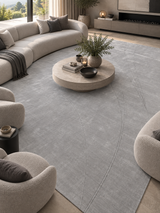 Alfombra Solstice Silver de lana en living con sofá curvo y mesa de centro redonda