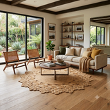 Alfombra redonda Dandelion Natural de cáñamo en living con sillones de madera y ventanales