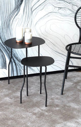 Alfombra Annu Warm Grey de Tencel junto a mesas laterales negras