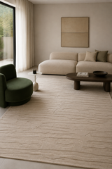 Alfombra Alina de lana en living con sofá modular blanco y sillón verde