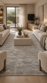 Alfombra Basanti Ivory Silver de Tencel en living con sofás blancos y mesa de centro de travertino