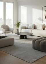 Alfombra Dalai Grey de lana en living con sofá blanco y mesa de centro negra
