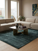 Alfombra Basanti Jade de Tencel en living con sofá beige y mesa de centro de vidrio