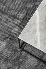 Detalle del tejido de la alfombra Komara Dark Grey de Tencel bajo mesa de centro de mármol