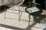 Alfombra Rustic White de cáñamo junto a sillón de cuerda y mesa negra