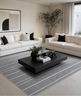 Alfombra Llana Charcoal de polipropileno en living con sofá blanco y mesa de centro negra