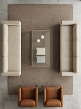 Vista cenital de la alfombra Tamil Apricot Tan de polipropileno en living con sofás blancos y sillones de cuero