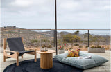 Alfombra redonda Black Chain de cáñamo en terraza con cojines de piso y vista al valle