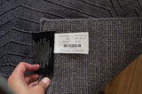 Detalle del tejido y etiqueta de la alfombra Varua Dark Grey de Tencel